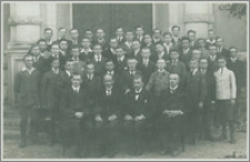 Nauczyciele i uczniowie przed budynkiem szkoły : pamiątka promocji do III klasy rok 1921 jesienią